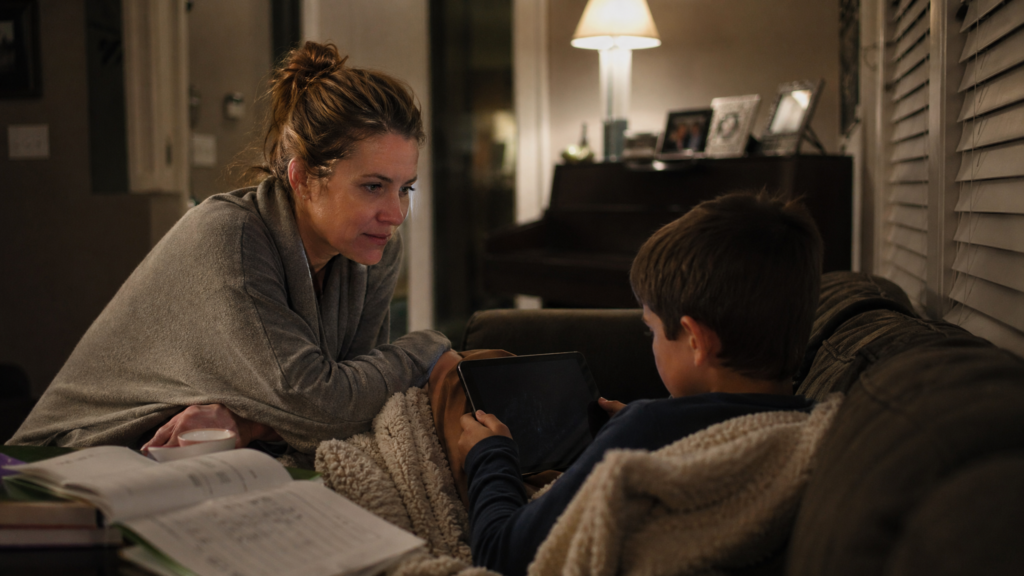 Parent calmly supporting a child using a tablet at night
